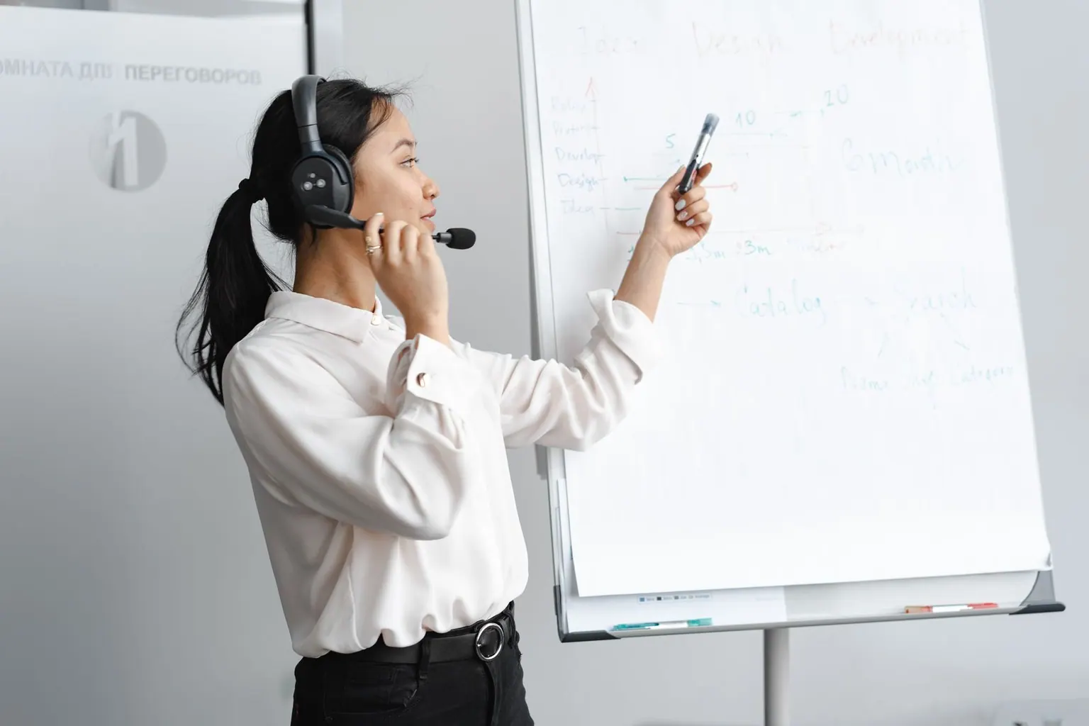 An Asian customer support agent working at her desk wearing a headset.