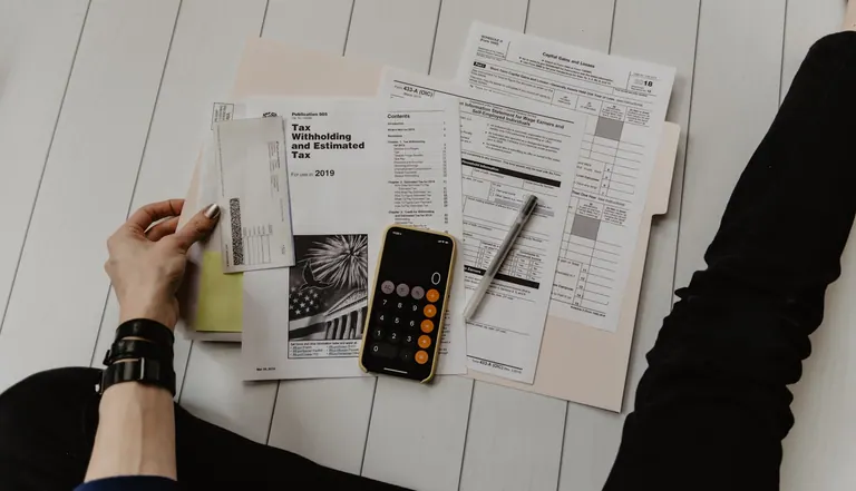 Accountant working through tax paperwork with a calculator