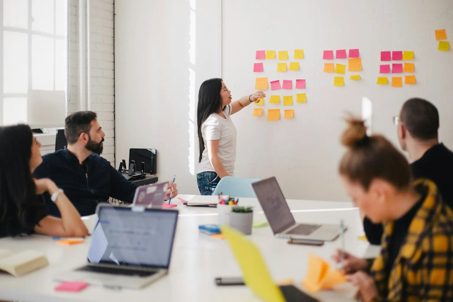 Team planning a campaign around a whiteboard of sticky notes