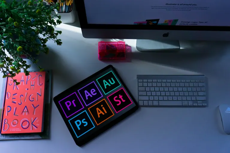 Designer's desk with creative software open on screen