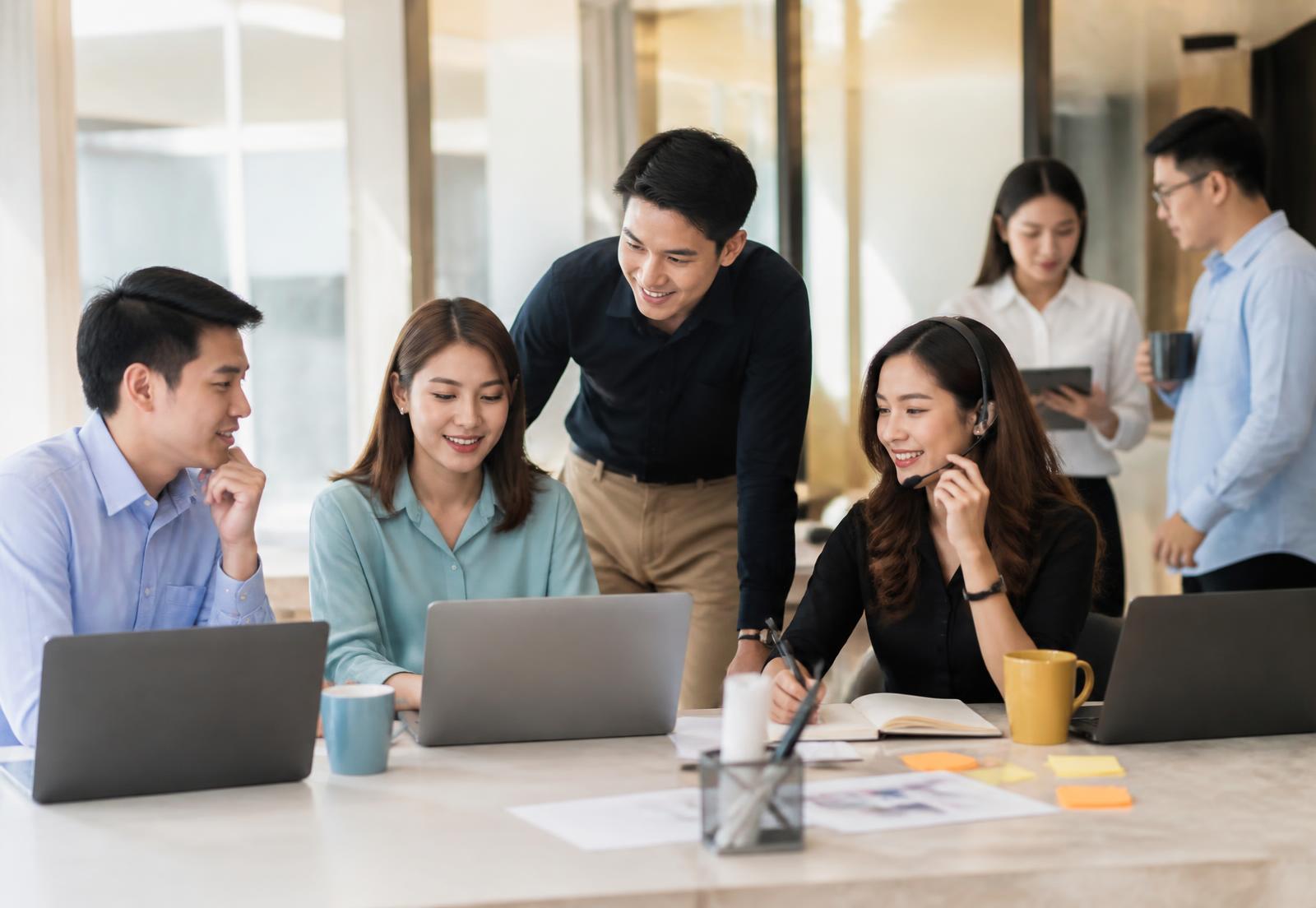 Asian professionals from different disciplines collaborating in a bright office.